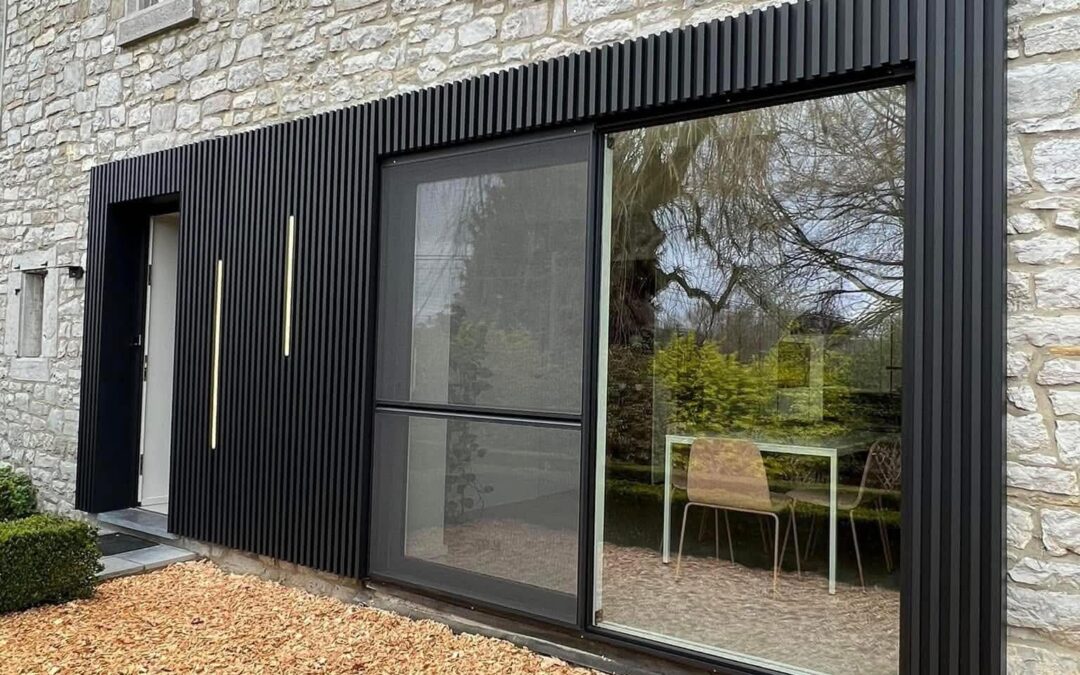 Bardage extérieur noir sur façade en pierre